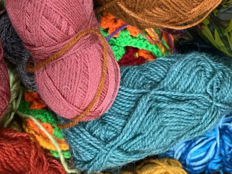 A heap of overlapping balls of yarn of many different colours